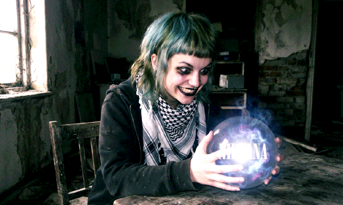 Snapshot of Nirvana Girl Witnessing Nirvana Solution A young woman with colorful hair dyed in washed out blue-green coloring blended with brown olive drab. She has black makeup, and a bob cut with a fringe that doubles as a mullet. She has a nose piercing, and a keffiyeh. She is firmly grasping a crystal ball, giving an exaggerated evil grin with unnatural proportions. Inside the glowing crystal ball, the text "NIRVANA" can be seen floating.