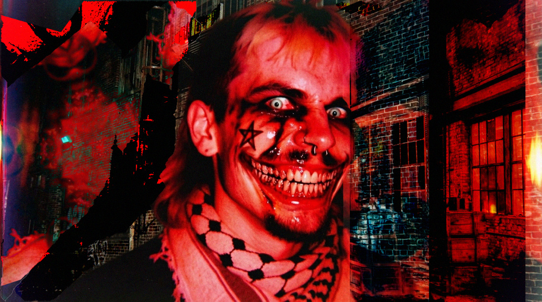 ... Creepypasta-style image of a man with a mullet wearing a keffiyeh with a wide surreal creepy grin. The entire image is corrupted and bathed in red colors.